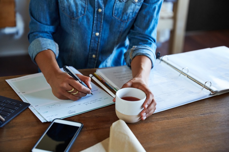 Woman writing a check at desk at work