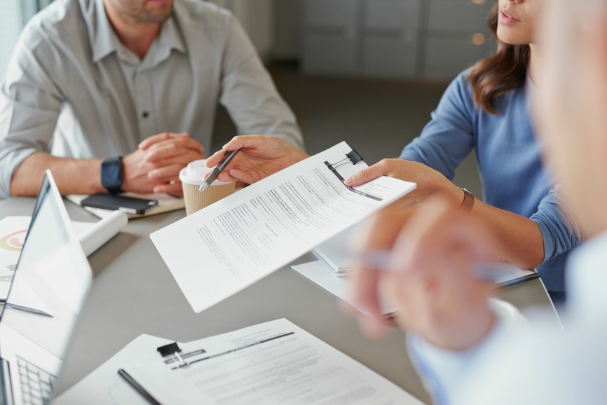 Business woman handing over legal document contract for signing in meeting